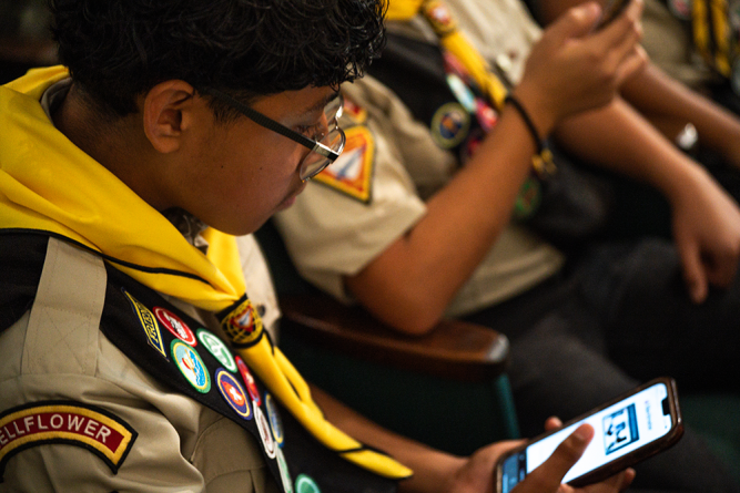 Pathfinders vote via phone for their favorite pins during a presentation on the upcoming International Pathfinder Camporee in Gillette, Wyoming.