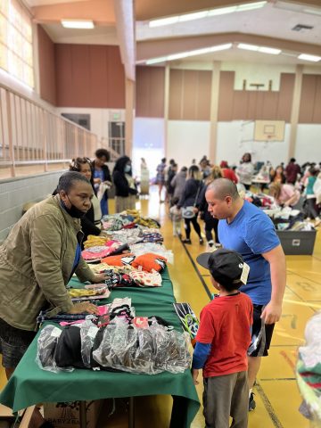 A family looks through the miscellaneous items available with the help of a volunteer.